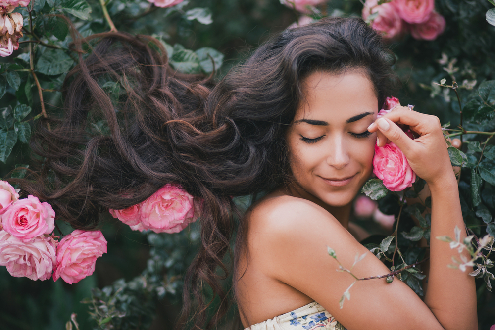 Beautiful,Young,Woman,With,Long,Curly,Hair,Posing,Near,Roses 752e2ede156e410b98b902062a44d69a