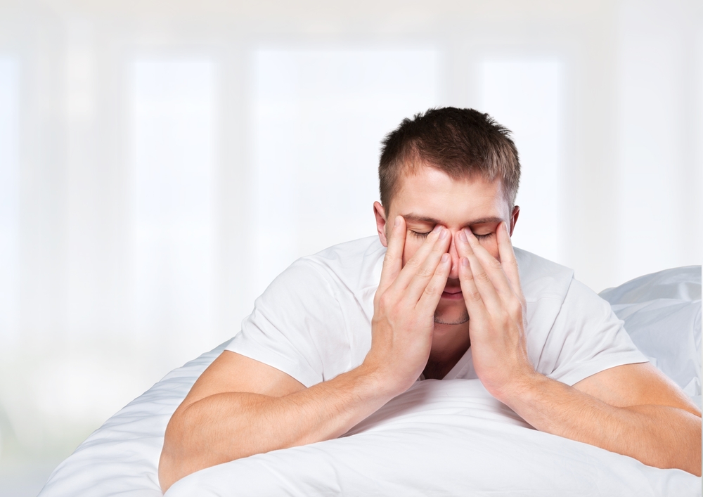 A man with low testosterone rubbing his eyes